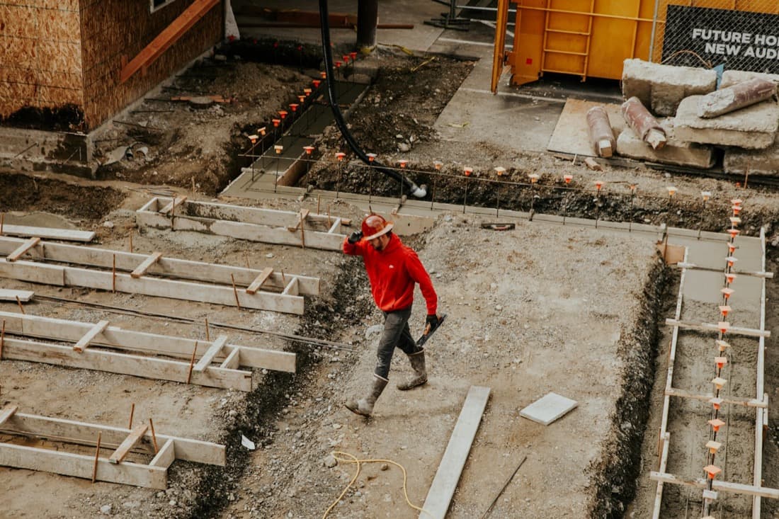 Curri carrier driver in a red jacket offloading materials at a delivery site — a branded delivery experience powered by Curri's third-party carrier network
