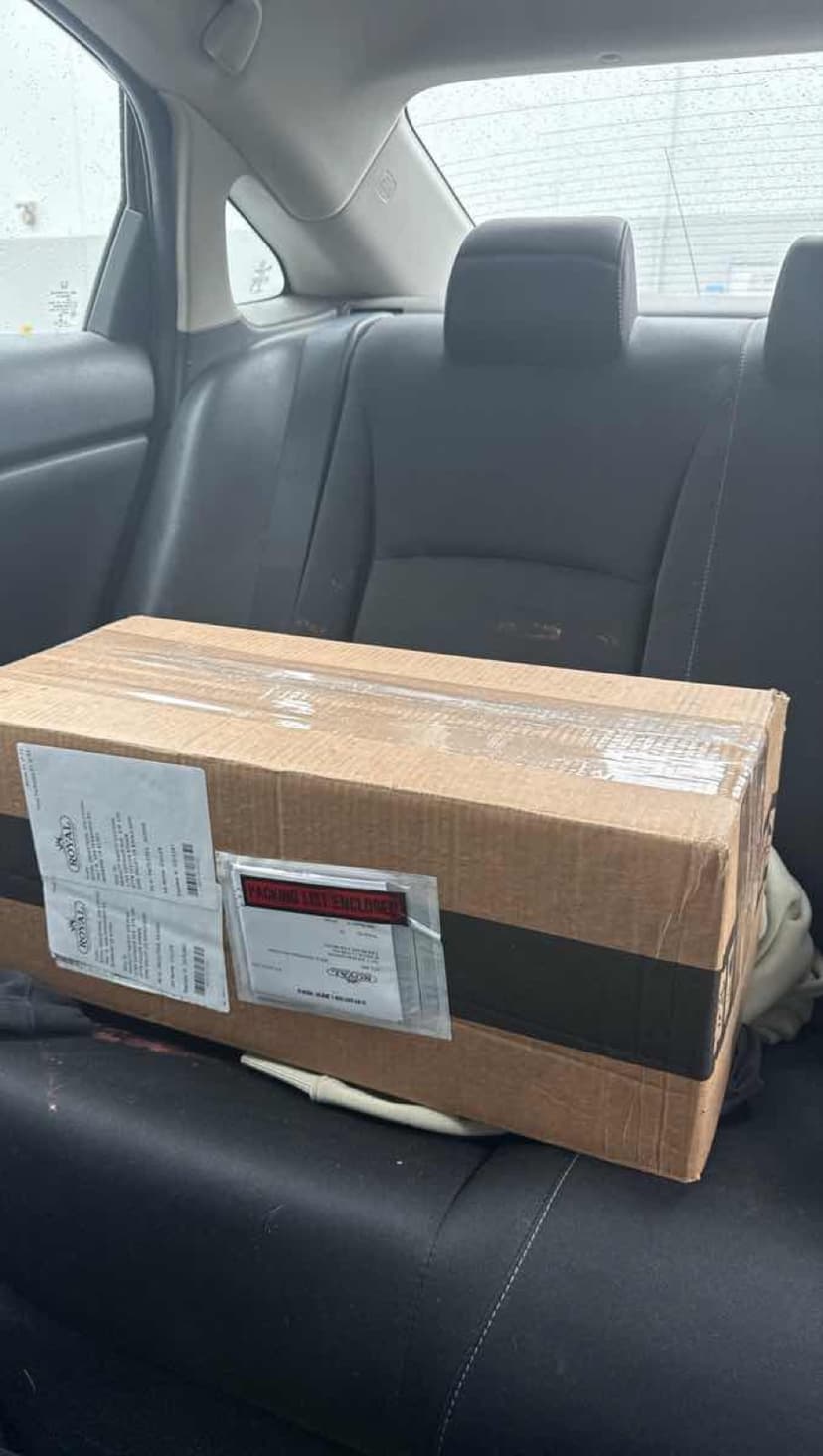 Curri car courier parked for a quick last-mile drop-off in a residential neighborhood