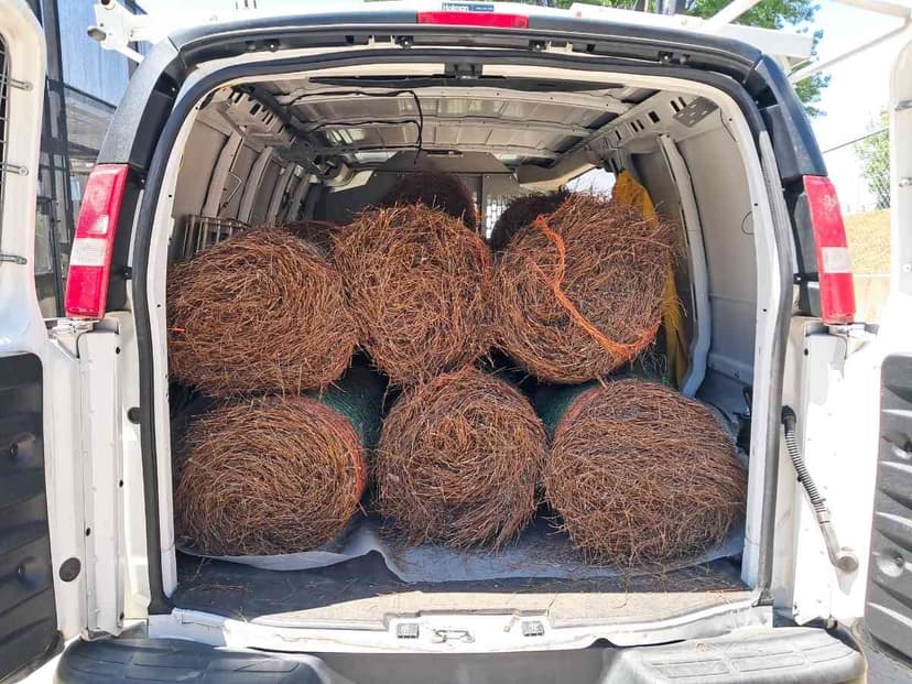 Cargo van rear loaded with bales of landscaping materials staged for a Curri same-day delivery