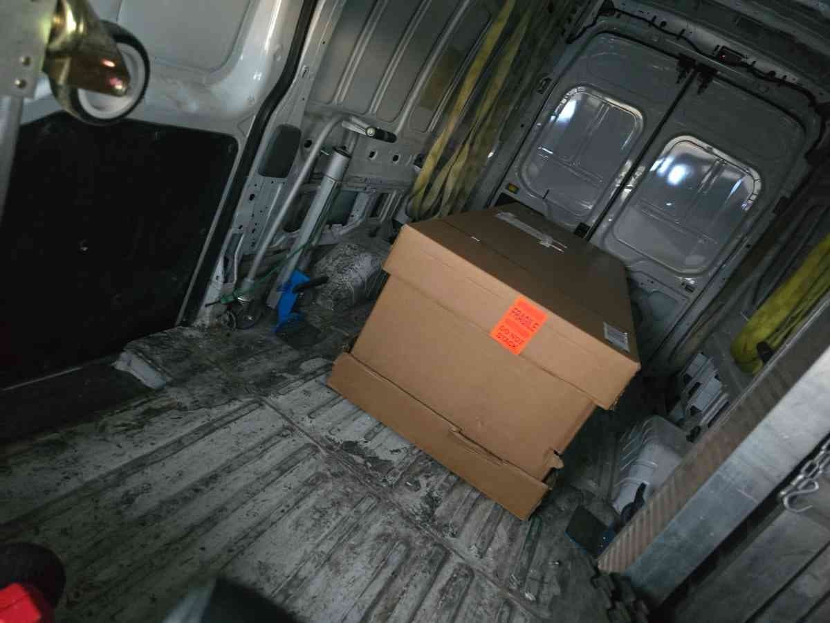 Cargo van interior with a fragile-marked carton secured for a careful last-mile drop on the Curri network