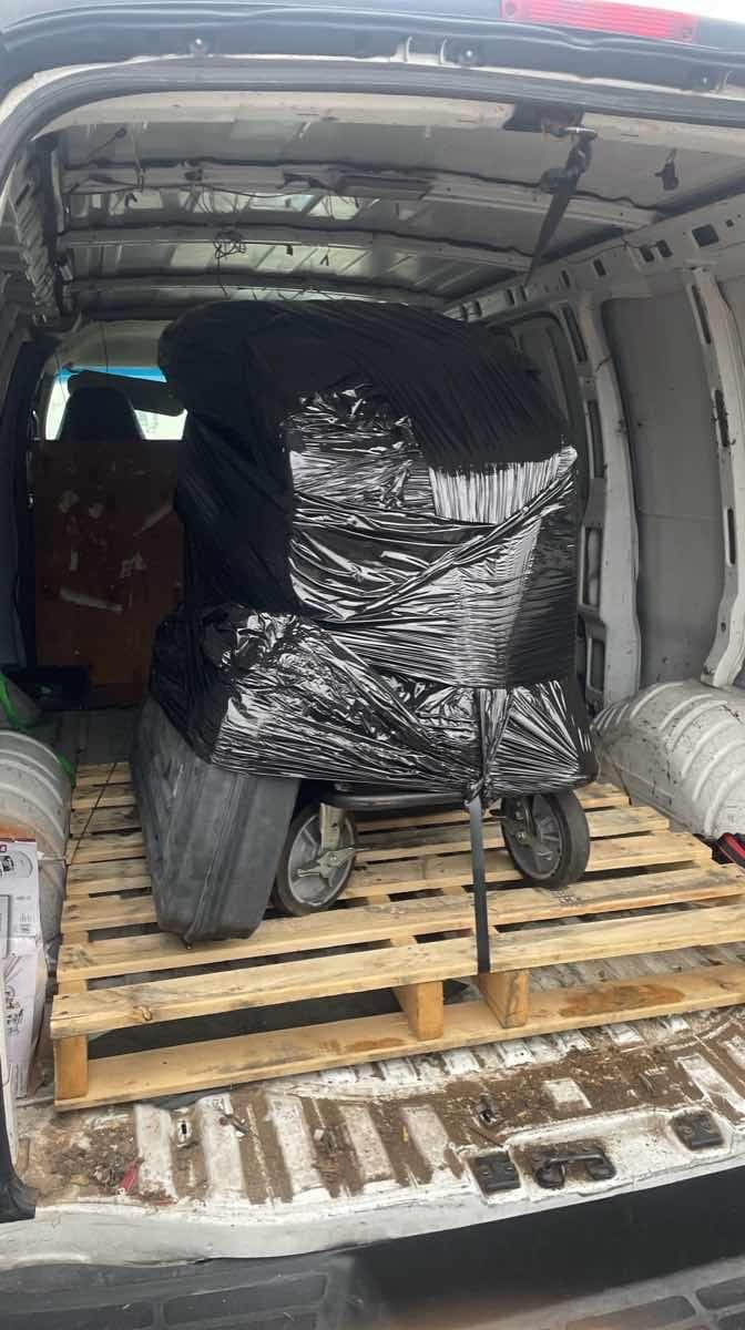 Shrink-wrapped equipment palletized inside a cargo van bay ready for Curri same-day delivery