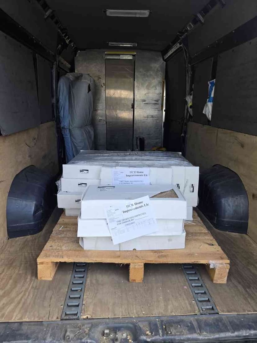 White cargo van parked at a lumber yard with side door open for a Curri same-day pickup