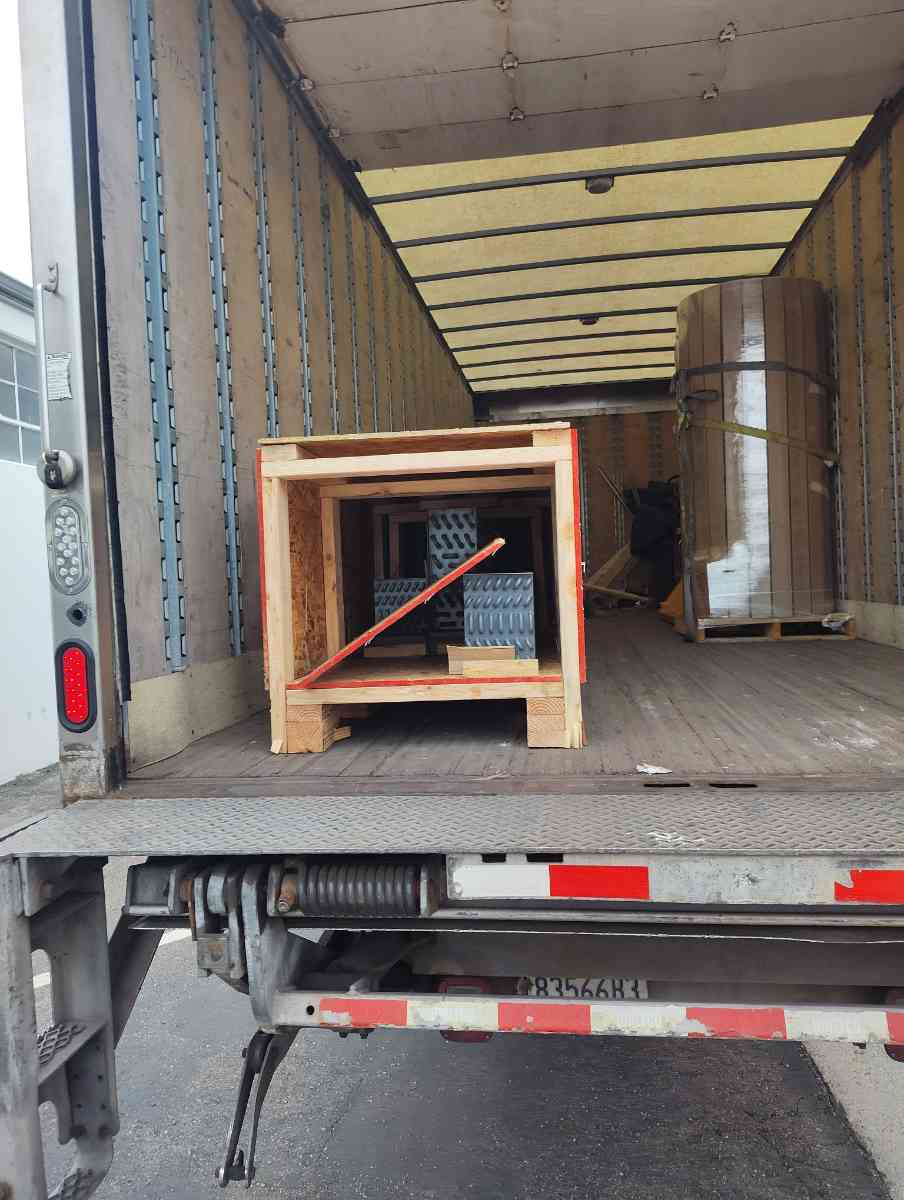 Crated freight inside a Curri dry van cargo bay with the liftgate ready for a same-day drop-off