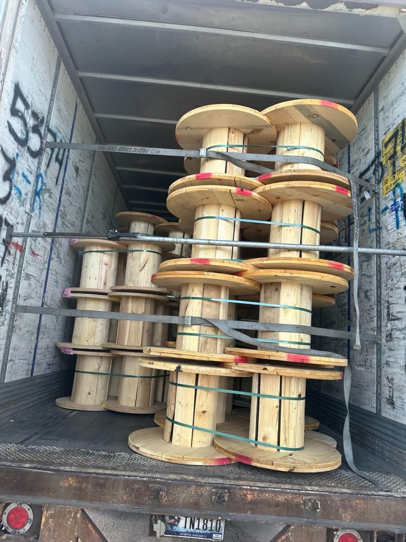 Wooden cable spools strapped inside a dry van trailer for a Curri industrial supply delivery
