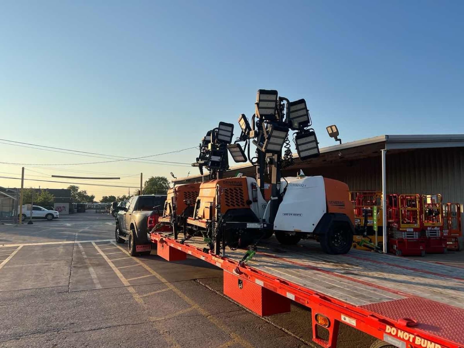 Flatbed hauling Generac light towers and rental equipment for a Curri same-day drop-off