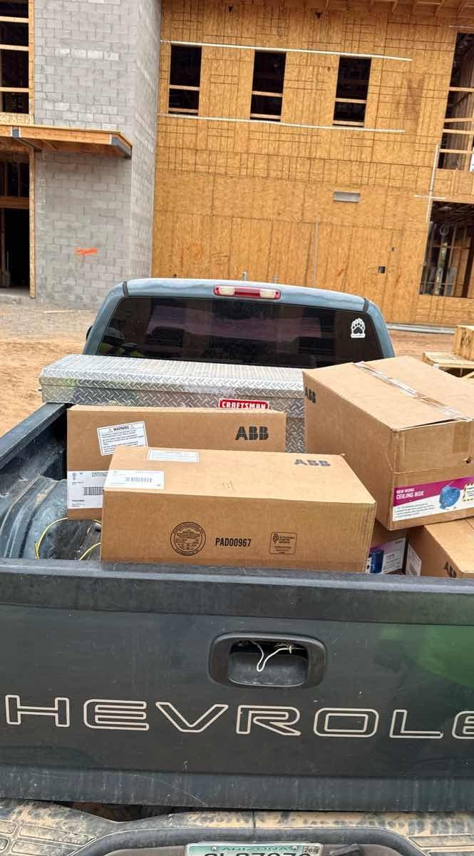 Chevrolet pickup truck bed loaded with ABB and Craftsman cardboard boxes at a delivery site for a Curri same-day delivery
