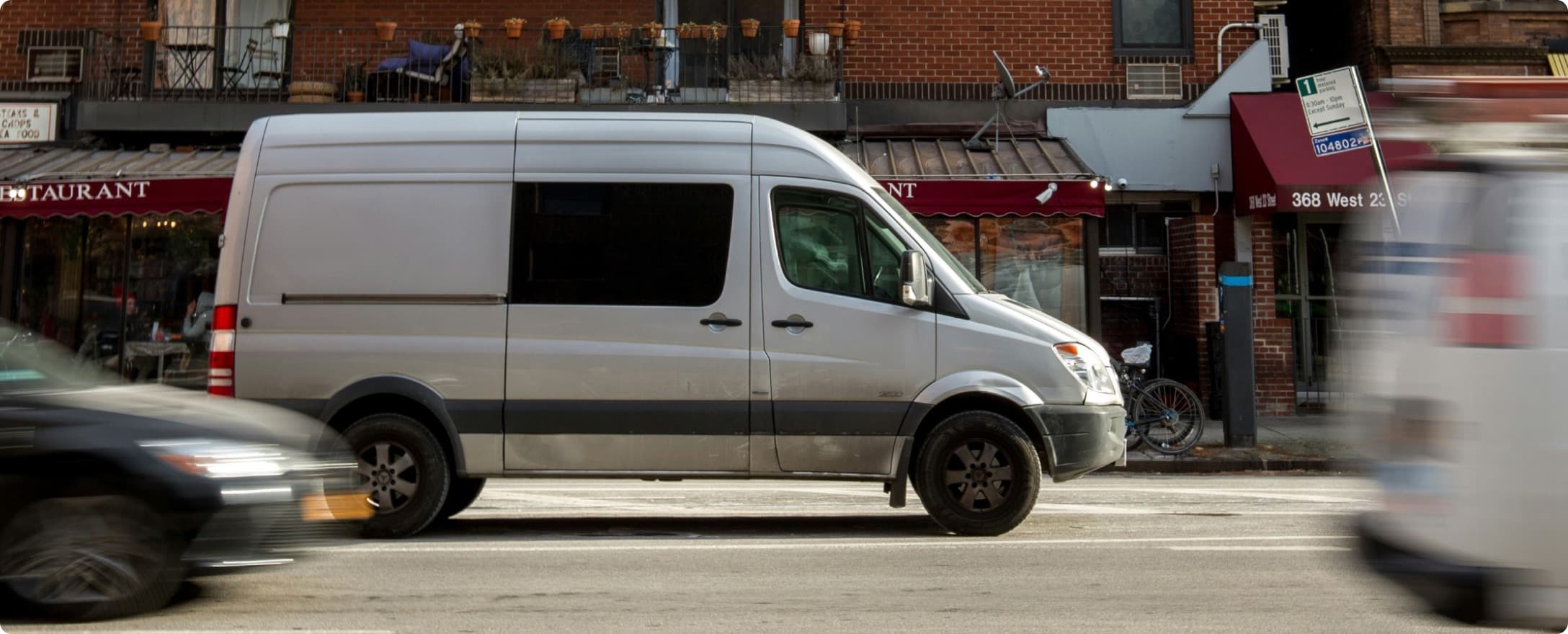 Curri nationwide delivery fleet Sprinter van completing a last-mile delivery through a busy city street